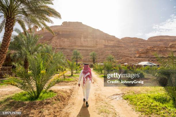 farm worker walking to agricultural fields in al-ula oasis - suadi arabia stockfoto's en -beelden