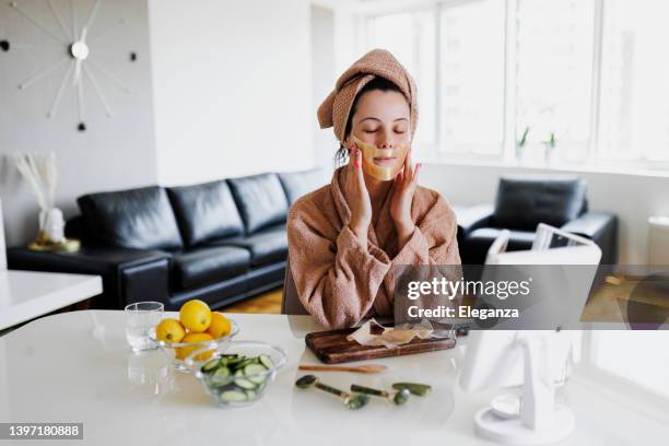 young woman applying face mask at home. natural skin care routine for glowing skin. woman at home having skin care routine. concept of natural cosmetics skin care - honey face mask stock pictures, royalty-free photos & images