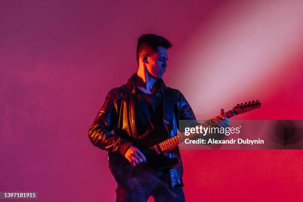 asian rock guitarist playing song on guitar enjoying music at performance - guitar player stock pictures, royalty-free photos & images