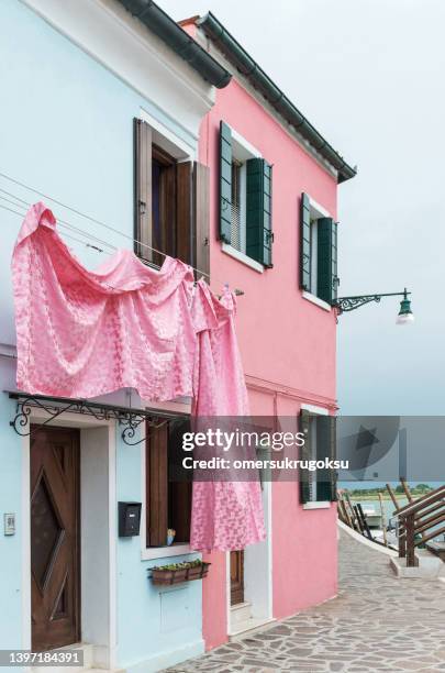 le lenzuola rosa sono appese a una corda - burano foto e immagini stock