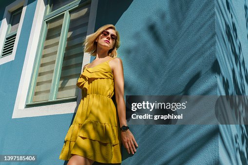 Retrato de mujer sonriendo contra la pared con sombra de palmera Retrato de mujer sonriendo contra la pared con sombra de palmera