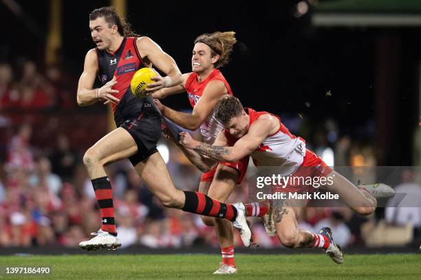 Sam Draper of the Bombers is tackled by James Rowbottom and Peter Ladhams of the Swans during the round nine AFL match between the Sydney Swans and...