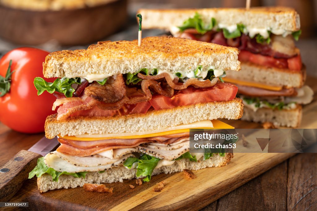 Club sandwich made with bacon ham turkey cheese lettuce and tomato