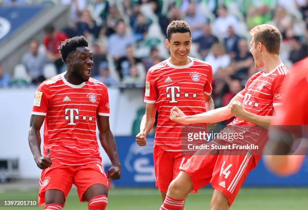 Josip Stanisic celebrates with teammates Alphonso Davies and Jamal Musiala of FC Bayern Muenchen after scoring their team's first goal during the...