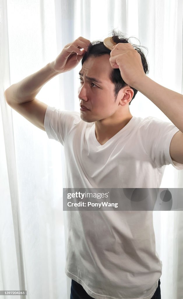 Homem preocupado com a queda de cabelo