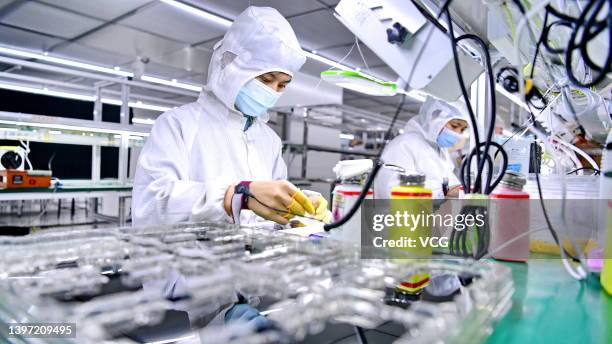 Employees work on the production line of the sceens for 5G smartphones at a factory on May 13, 2022 in Ganzhou, Jiangxi Province of China.
