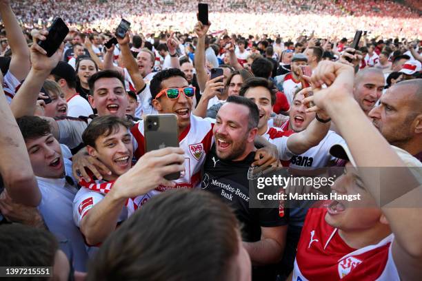 VfB Stuttgart fans celebrate alongside Tiago Tomas of VfB Stuttgart on the pitch after their side avoided relegation play offs after their sides...