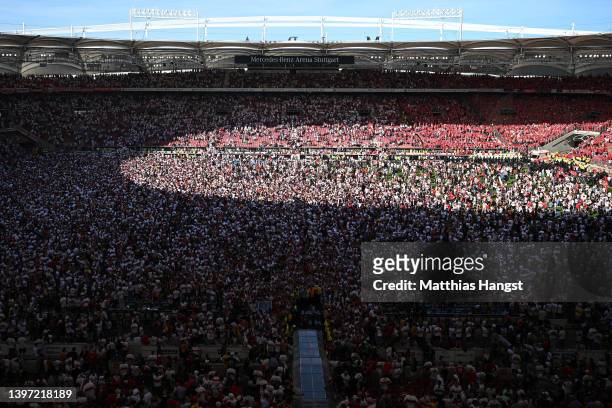 VfB Stuttgart fans celebrate on the pitch after their side avoided relegation play offs after their sides victory during the Bundesliga match between...
