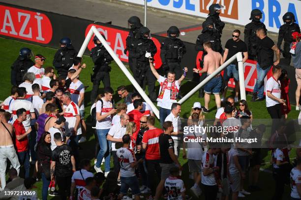 VfB Stuttgart fans celebrate on the pitch with the goal posts after their side avoided relegation play offs after their sides victory during the...