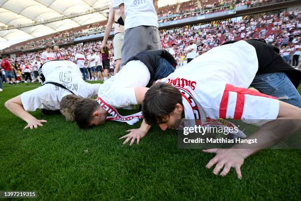 VfB Stuttgart fans kiss the pitch after their side avoided relegation play offs after their sides victory during the Bundesliga match between VfB...