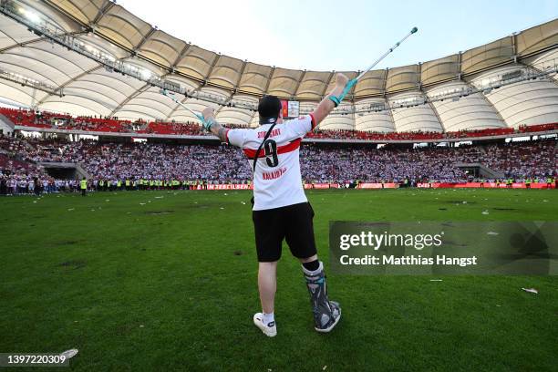 Fan celebrates on the pitch with their right foot in a cast after their sides victory, which means VfB Stuttgart avoid the relegation play offs in...