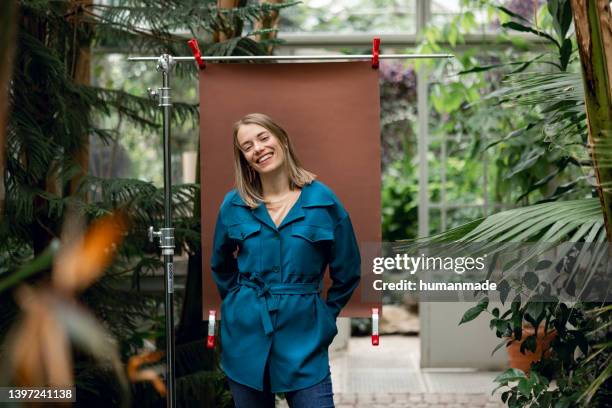 happy young woman in a botanical garden - photo shoot stockfoto's en -beelden