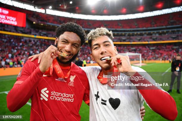 Joe Gomez and Roberto Firmino of Liverpool celebrate by biting their FA Cup winning medals following their team's victory in the penalty shoot out...