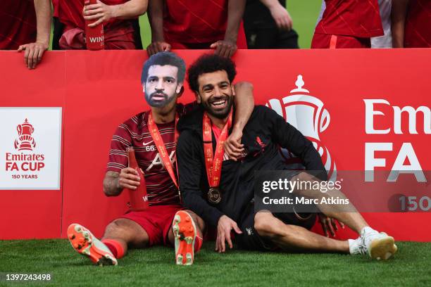 Thiago of Liverpool wears a mask of Mohamed Salah of Liverpool's face, as he and Mohamed Salah of Liverpool celebrate following their team's victory...