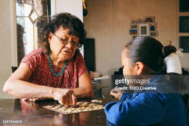 grandmother and grandson playing a game - navajo etniciteit stockfoto's en -beelden