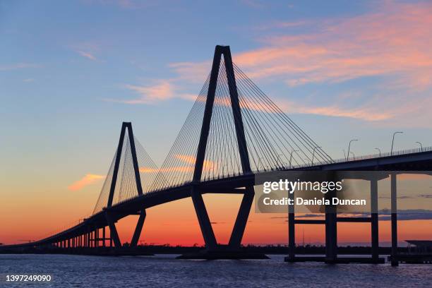 the cooper river bridge at sunset - carolina del sud foto e immagini stock