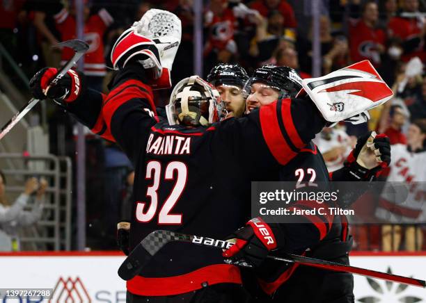 Antti Raanta of the Carolina Hurricanes celebrates with Brett Pesce and Jaccob Slavin following their 3-2 victory over the Boston Bruins in Game...