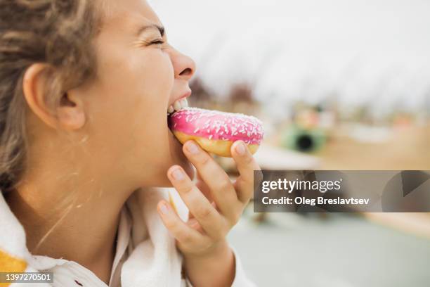 overweight hungry woman biting donut close up. concept of unhealthy fast food eating - fat people eating donuts 個照片及圖片檔