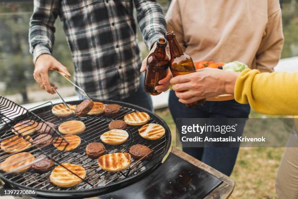 friends having barbecue in home backyard. - burger on grill photos et images de collection
