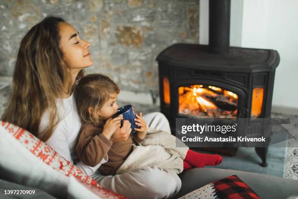 happy family resting near fireplace at home. - chaussette noel cheminée photos et images de collection