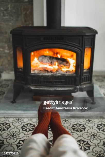 feet in knitted socks near fireplace in winter time. - chaussette noel cheminée photos et images de collection