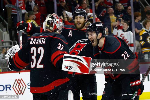Antti Raanta of the Carolina Hurricanes celebrates with Brett Pesce and Jaccob Slavin following their 3-2 victory over the Boston Bruins in Game...