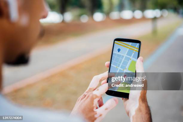 man with vitiligo using gps on the walk - systemic lupus erythematosus stock pictures, royalty-free photos & images