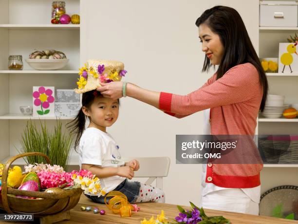 chinese mother and child with easter bonnet - easter bonnet hats stock pictures, royalty-free photos & images