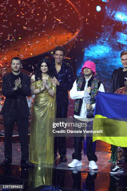 Alessandro Cattelan, Laura Pausini and Mika pose on stage with the Eurovision Song Contest winners, the Kalush Orchestra, representing Ukraine,...
