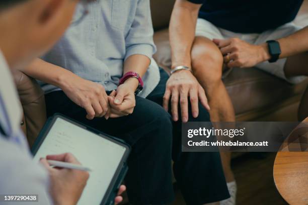 female doctor consult old couple patients in hospital - clinic stockfoto's en -beelden