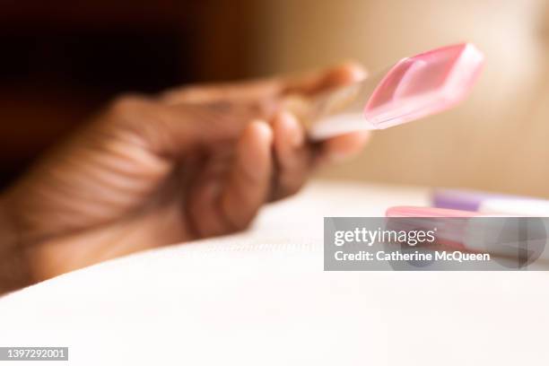 black woman reading results of three at-home pregnancy tests - ovulation stock pictures, royalty-free photos & images