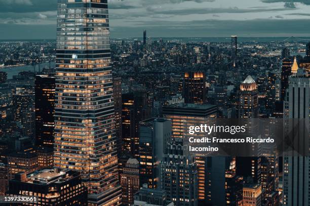 night skyline of buildings in cinematic look. - bright lights big city visions of new york at night stockfoto's en -beelden