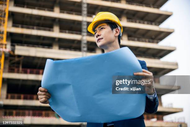 engineer supervising building process in a building sites - construction crane asia stockfoto's en -beelden