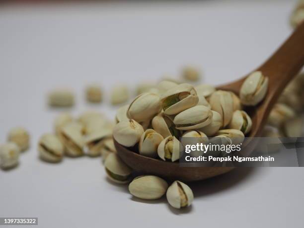 pistachio dried bean in wooden spoon, snack food background - crack spoon stock pictures, royalty-free photos & images