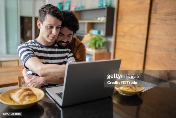 gay couple using laptop during breakfast at home - breakfast pastries stock pictures, royalty-free photos & images