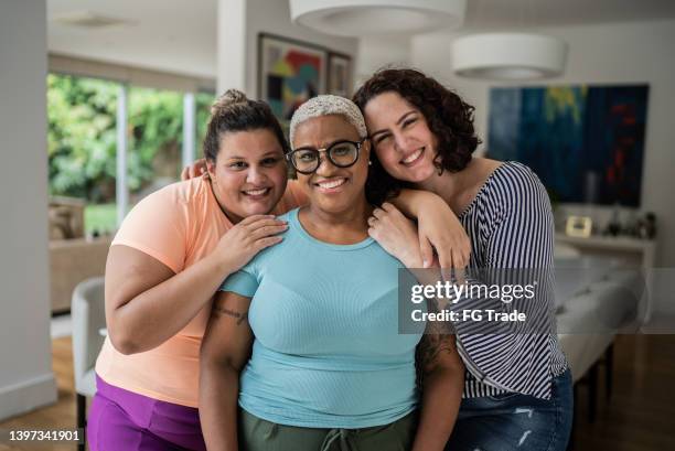 portrait of female friends at home - overweight stockfoto's en -beelden