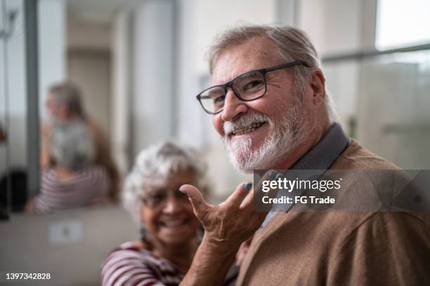 senior woman taking care of her husband in the bathroom at home - senior getting dressed stock pictures, royalty-free photos & images