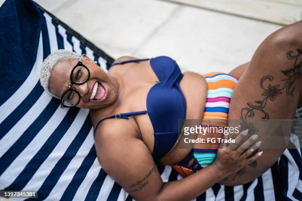 mature woman laughing in a pool at home - curvy black women stockfoto's en -beelden
