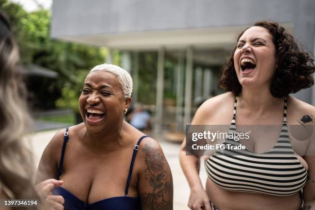 female friends with swimwear enjoying pool together at home - curvy black women stockfoto's en -beelden