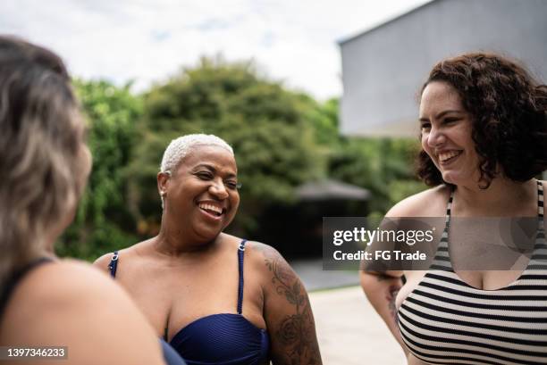 happy friends on swimwear enjoying pool together at home - morbidly obese woman 個照片及圖片檔