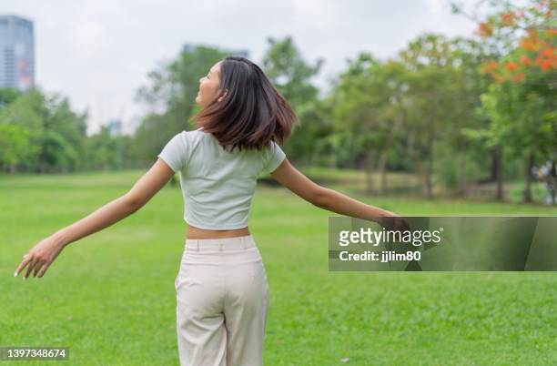 jeune femme asiatique se détendre et se détendre dans un parc - bachelorette photos et images de collection