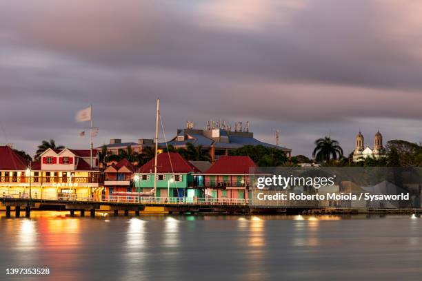 buildings reflected in the sea at dusk, st johns, antigua - セントジョンズ ストックフォトと画像