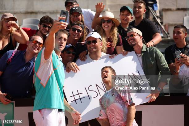 John Isner of the United States and Diego Schwartzman of Argentina take a photo with fans after their defeat against Nikola Mektic and Mate Pavic of...