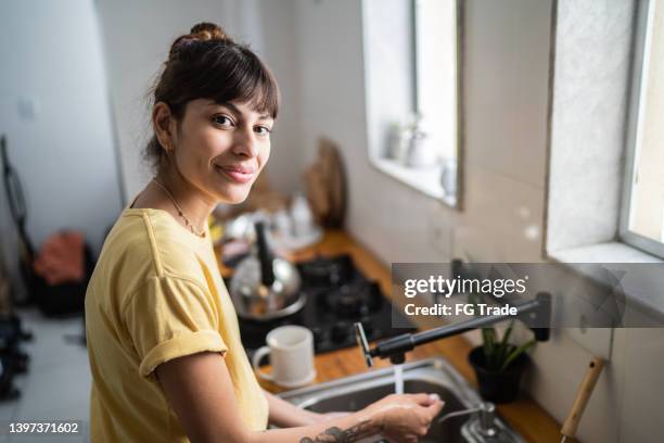 portrait d’une jeune femme faisant la vaisselle à la maison - agent de ménage photos et images de collection