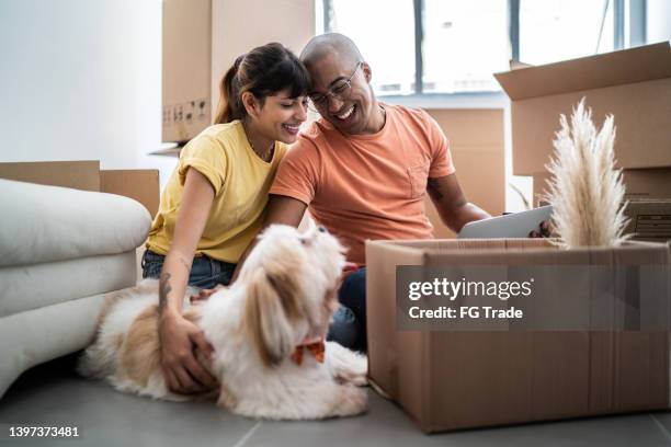 young couple packing and moving boxes at home - 解開包裹 個照片及圖片檔