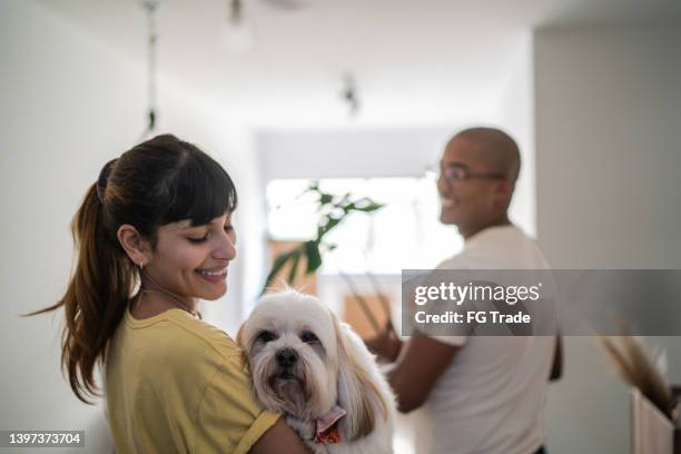 young woman enjoying dog at home - woman entering home stock pictures, royalty-free photos & images