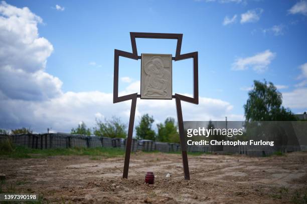 Memorial cross is erected at the site of a mass grave on May 15, 2022 in Bucha, Ukraine. As Russia concentrates its attack on the east and south of...