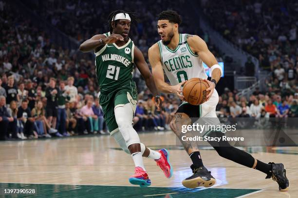 Jayson Tatum of the Boston Celtics is defended by Jrue Holiday of the Milwaukee Bucks during Game Six of the Eastern Conference Semifinals at Fiserv...