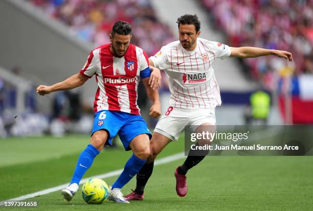 Koke of Atletico Madrid battles for possession with Joan Jordan of Sevilla during the LaLiga Santander match between Club Atletico de Madrid and...