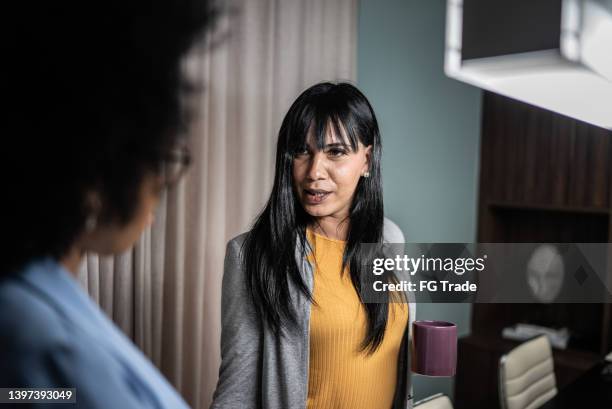 transgender female talking with colleague on meeting in the office - gender stereotypes stock pictures, royalty-free photos & images